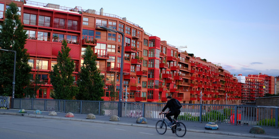 Eine Straße mit roten Wohnhäusern.