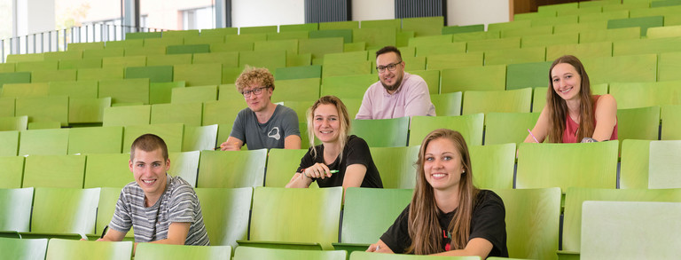 A group of students are sitting in a lecture hall.