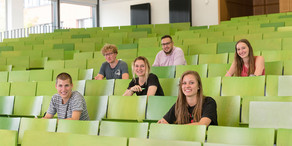 A group of students are sitting in a lecture hall.